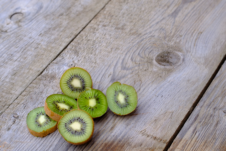 on the old weathered board there are six parts of kiwi, green fruit with seedsの写真素材