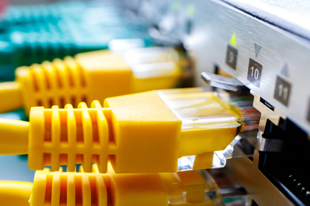 yellow patch cords are inserted into the ports of the switch of a type, an access point for all subscribersの写真素材