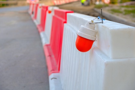 the red light on the plastic enclosure during the repair of the bridge, stretching into the distance plastic temporary fenceの写真素材