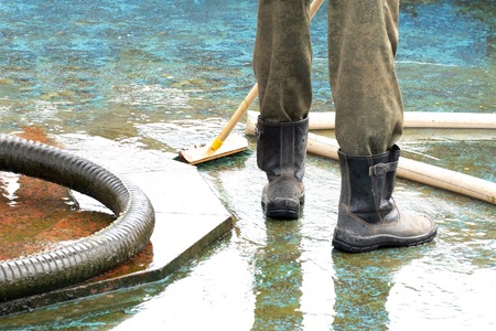 pool or fountain cleaner boots, brush removes debris from the surface, corrugated hose and old painted surfaceの写真素材