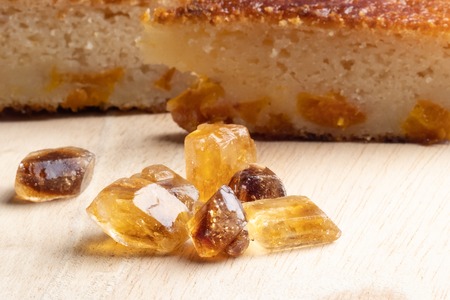 in the foreground, the sugar cane pieces lies on a wooden surface, the background pieces of cakeの写真素材