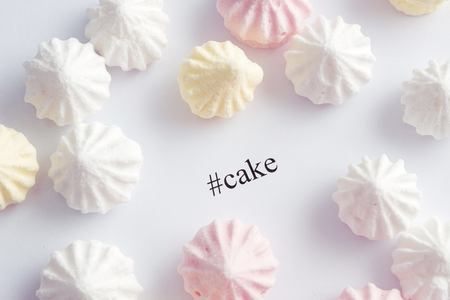 tag cake is written on a white background next to meringue cake white, yellow and pink sweet cakes