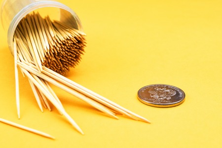 toothpicks on a yellow background scattered on the table and an iron coin rubleの写真素材