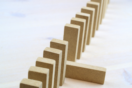 a row of rectangular wooden bars, one of the bars fell, light backgroundの写真素材