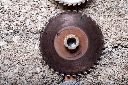 large rusty saw blade from an electric saw hanging on the barn wallの写真素材