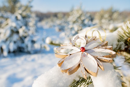 Christmas tree decoration made with their own hands is on a green pine branch, winter time, background forest and snowの写真素材