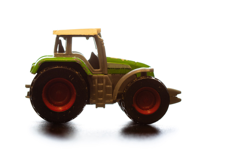 toy tractor on a light background with wear elements on the body and wheelsの写真素材