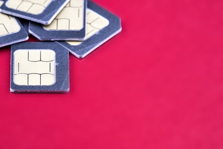 five SIM cards for smartphone on the edge of the frame, red backgroundの写真素材