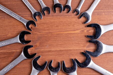 laid out around wrenches in the center of their void wooden backgroundの写真素材
