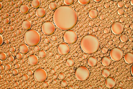 orange abstract background of soap bubbles on the water surface, round bubbles on the surface