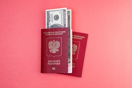 two Russian passports on the background of one of the passports inserted moneyの写真素材