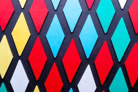 Vertical background from a variety of shapes in a video diamond pattern of various colors on a black background.の写真素材