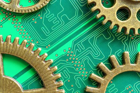 old technology of mechanical gears made of brass and modern computer chip technologyの写真素材