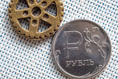 round gear and the round coin with face value of one ruble on the background fabric mattingの写真素材
