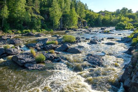 fast rushing river with rapids, muddy yellow water running among the stones. dangerous flows