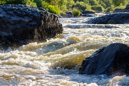 view of the river from the lower point waves and splashes of the river on the rapids a lot of stones a dangerous momentの写真素材