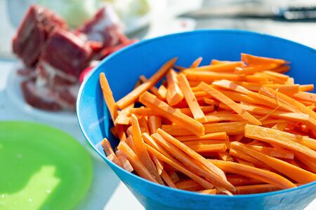 carrots pilaf ingredients in the foreground sliced meat in the backgroundの写真素材