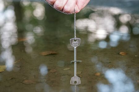 a key on a metal chain is lowered into the water to drown hide evidence
