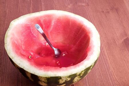 a sliced red ripe watermelon with a spoon stuck in it. spoon ate watermelon like a cupの写真素材