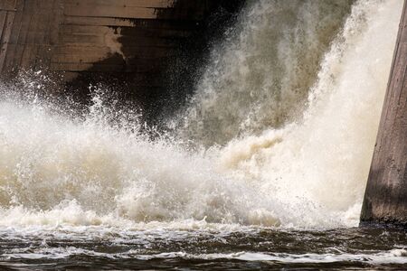 water spray and foam from falling through a lock in a dam on the river. river dam old