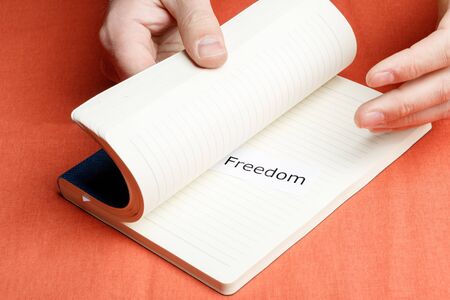 hands opened a diary and there a piece of paper and the inscription freedom. call to actionの写真素材