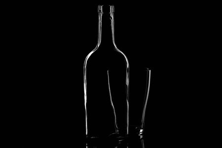 Photogary contours of the bottle and glass on a black background. abstract photo of glass objects for interior decorationの写真素材