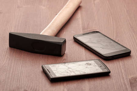 big metal hammer and broken smartphones. smartphone addiction elimination