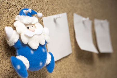 toy Santa Claus on a cork surface next to him stickers for reminder. christmas to-do listの写真素材