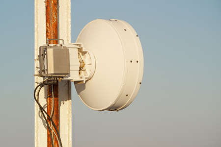 round cellular transmitter close-up on stand outside, sky background. one of the elements of cellular communicationの写真素材