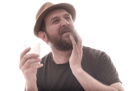 a dreamy, bearded man with a glass of milk in his hand. harm or benefit from milk