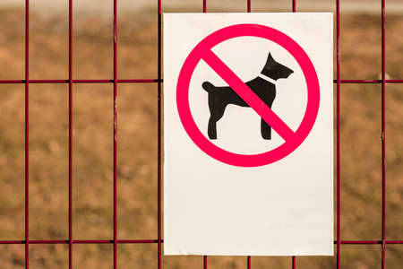no dog walking sign on the bars, the background is blurred. forbidden to walk dogs