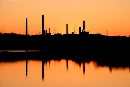 silhouette of factory pipes on the background of sunset, inoperative factory. stopped productionの写真素材