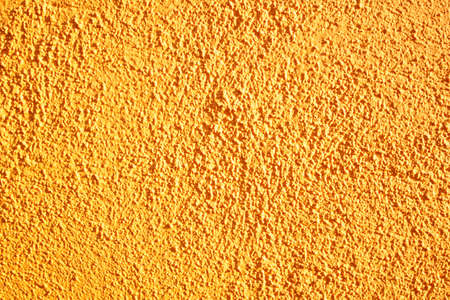 rough orange wall surface with irregularities. wall texture in pimplesの写真素材