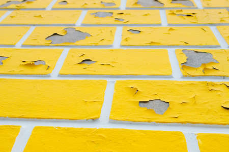 wall with peeling yellow paint, poorly painted wall