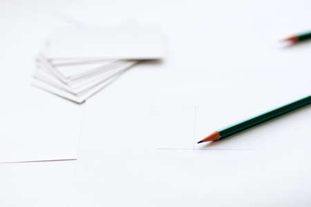 pencil close up on foreground, background out of focus blurred business cards