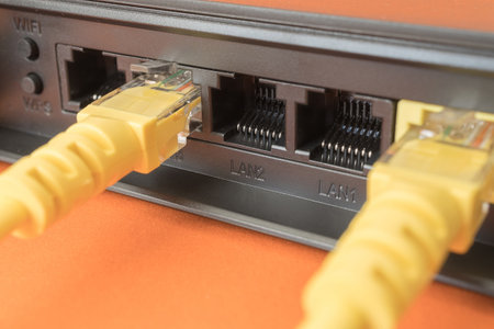 black router in which yellow patch cords are inserted. wired internet access point