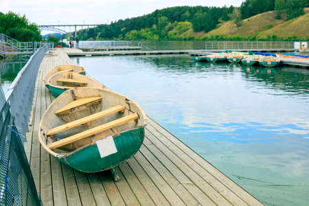 boats lying at the boat station on the pier in the process of drying and inspection before renting. summer day riverbank at the boat stationの写真素材