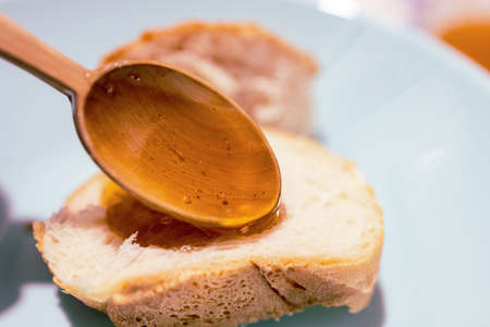 on a piece of bread a spoon with honey, fresh honey and bread healthy foodの写真素材