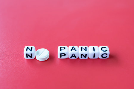 the inscription no panic instead of the letter o round white tablet, cubes on a red backgroundの写真素材
