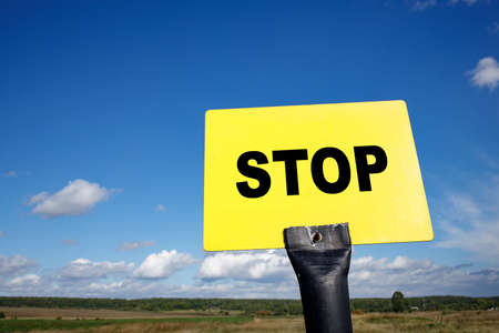 yellow sign with black letters inscription stop, warning sign no furtherの写真素材