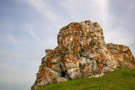 big stones on the top of the hill, grass grows on the hill on a summer dayの写真素材