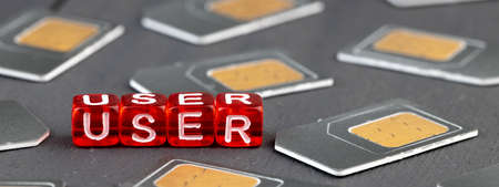 user written in white letters on red lips around sim card cubes on a wooden surfaceの写真素材