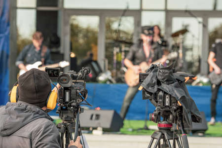 videographer filming an outdoor concert, video broadcast from a street concert