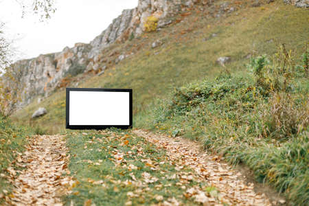 road on in the mountains and part of the sky, in the foreground a TV with a blank screen for an inscription. weird case tv on the roadの写真素材