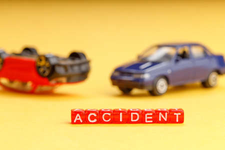 toy car crash on yellow background close-up out of focus blurred foreground inscription accidentの写真素材