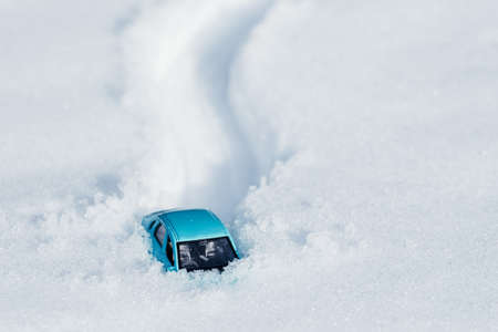 footprints and a car in the snow, a car stuck in a large pile of snow. snowfall on the roadの写真素材