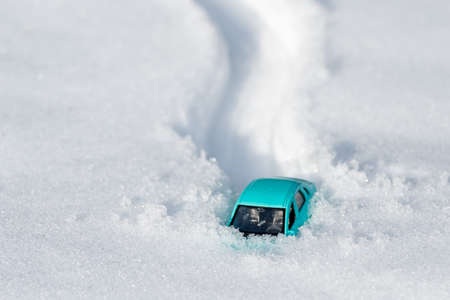 the toy car got stuck in the snow, after the car the trail is deep in the snow. a lot of snow fell, covered the roadの写真素材
