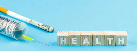 banner on which a syringe and wooden cubes without an inscription. the inscription health on the cubesの写真素材