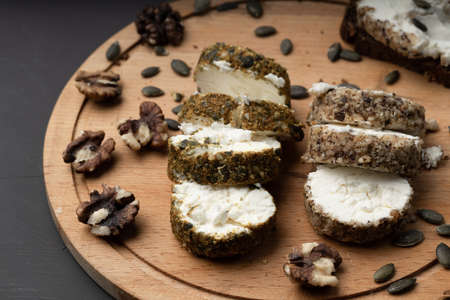 cheese cut into wedges next to walnuts on a wooden cutting board. lunch in the village