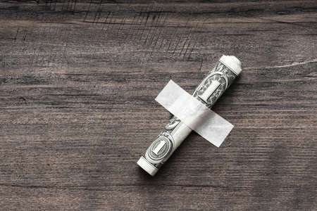 the dollar is rolled into a tube and fixed to a wooden surface. as a last resortの写真素材